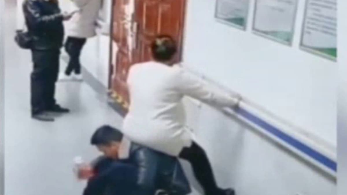 Embarazada se sienta sobre la espalda de su esposo en sala de espera