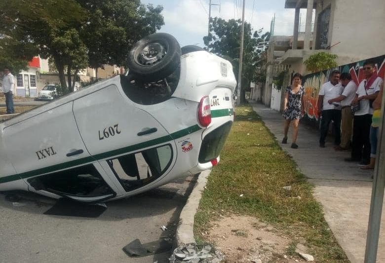 Taxi queda con sus llantas en el aire, tras choque en Cancún