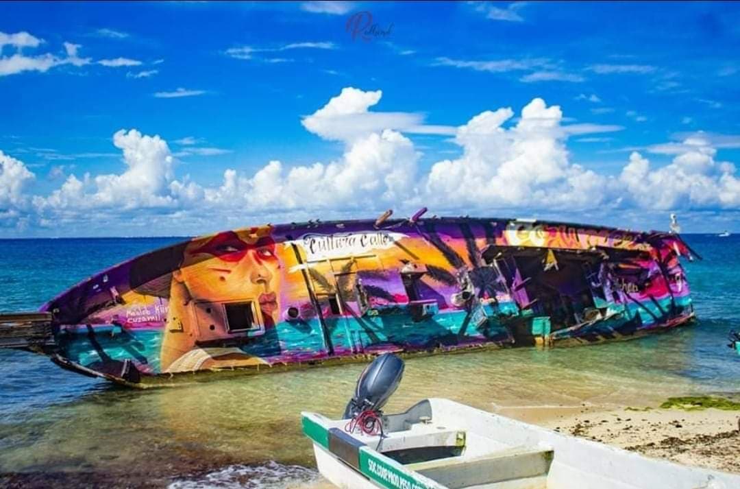 Pinta artista publicidad en barco encallado; artistas locales lo tapan