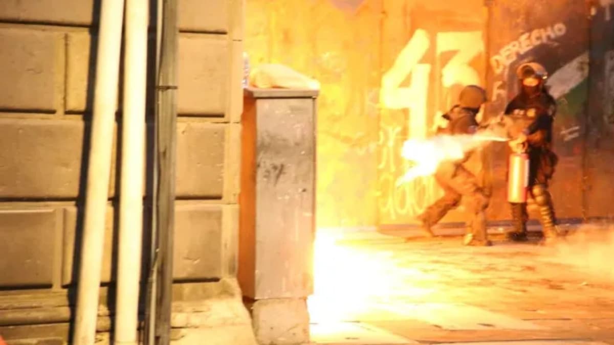 Video: Manifestantes lanzan petardos durante marcha por Ayotzinapa en el Zócalo de la CDMX