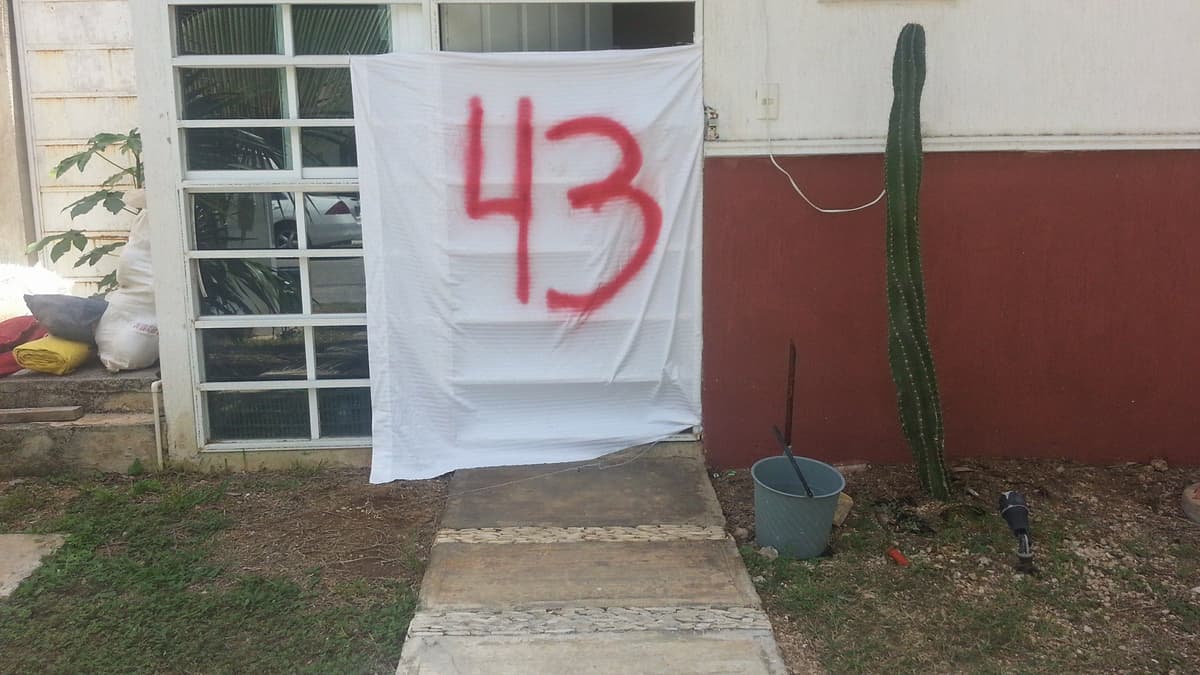 Mujer es intimidada por vecinos por colgar manta en apoyo a los 43 de Ayotzinapa