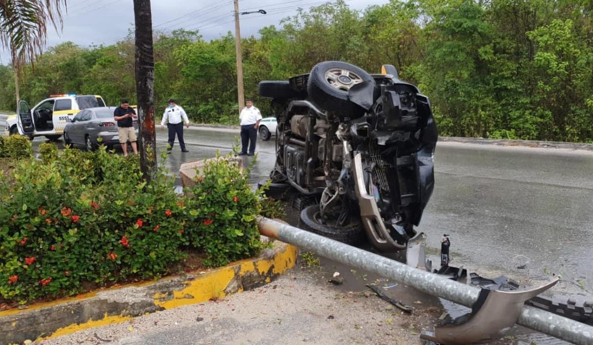 Por el asfalto mojado, camioneta pierde el control y se vuelca sobre el Arco Vial de Cancún
